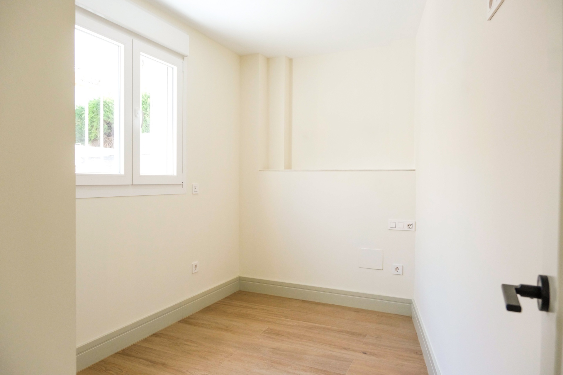 Dormitorio luminoso con acabados premium y suelo de madera